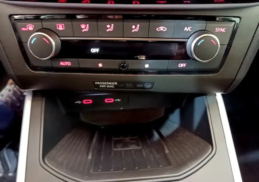 Vue rapprochée de la console centrale du SEAT Arona 2022, mettant en valeur la climatisation digitale et la zone de recharge sans fil.