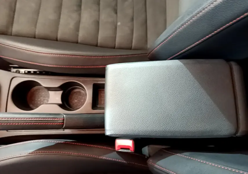 Gros plan sur la console centrale et les sièges noirs avec surpiqûres rouges du SEAT Arona 2022 finition FR.