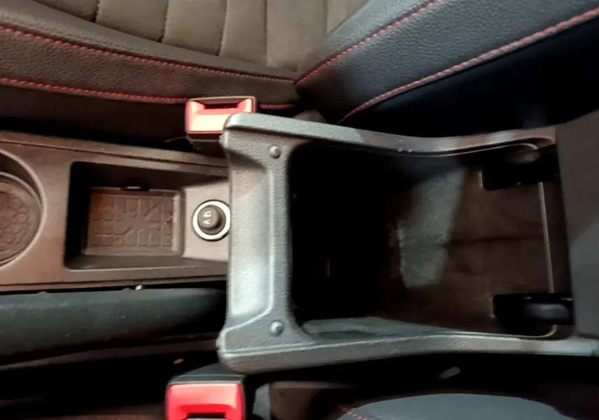 Vue plongeante sur la console centrale noire avec rangement ouvert et surpiqûres rouges des sièges du SEAT Arona bleu 2022.