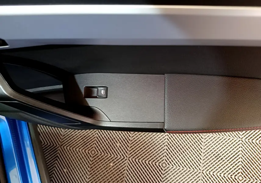 Détail de la porte côté gauche d'une SEAT Arona bleu 2022 avec bouton de verrouillage intégré.