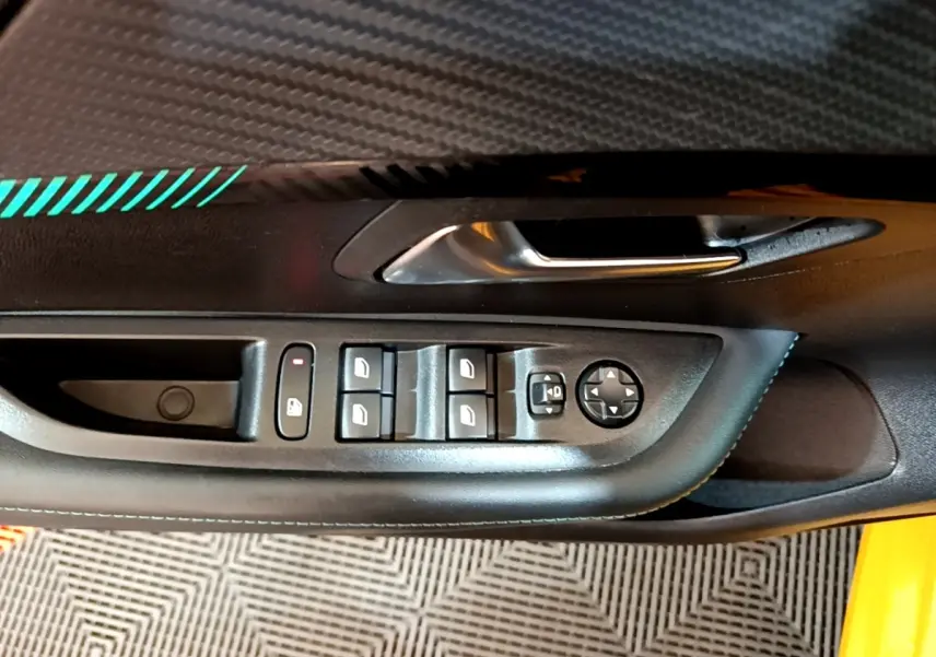 Gros plan sur la commande des vitres et rétroviseurs côté conducteur d'une Peugeot 208 jaune 2023.