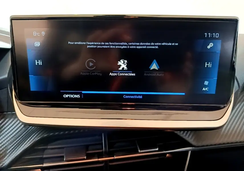 Écran tactile central de la Peugeot 208 jaune 2023 affichant les options Apple CarPlay et Android Auto.