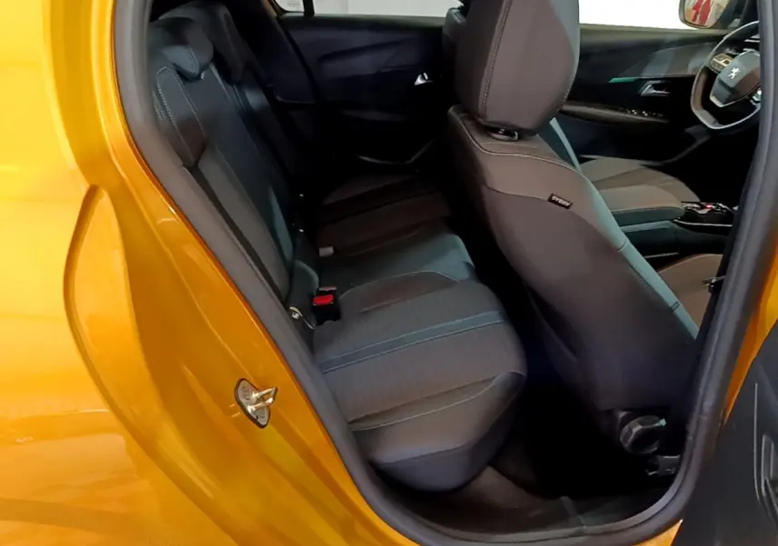 Vue intérieure côté arrière gauche d'une Peugeot 208 jaune 2023, montrant les sièges arrière et avant en tissu noir.