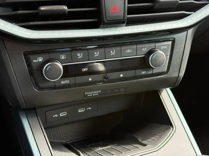 Vue rapprochée du tableau de bord du SEAT Arona 2025, mettant en valeur les commandes de climatisation et les ports USB.