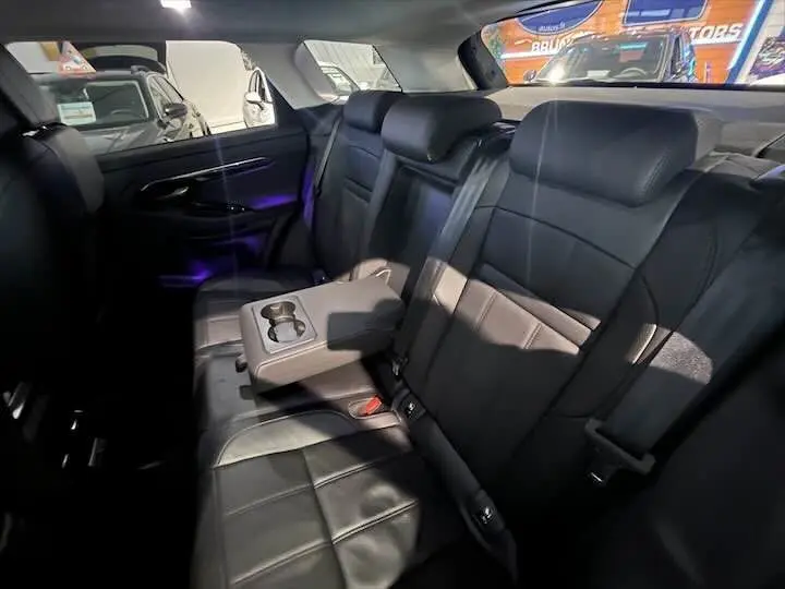 Vue intérieure arrière du Range Rover Evoque 2020 avec sièges en cuir noir grainé et accoudoir central relevé.