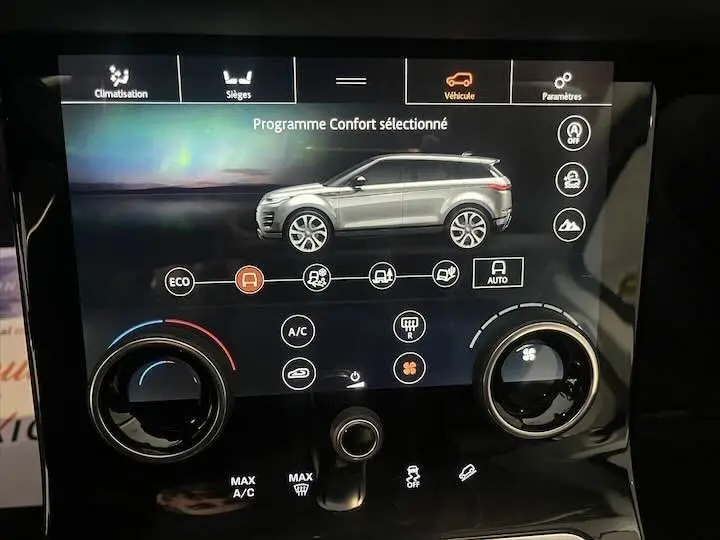 Écran tactile du tableau de bord montrant un Range Rover Evoque gris en profil droit avec options de conduite et climatisation.