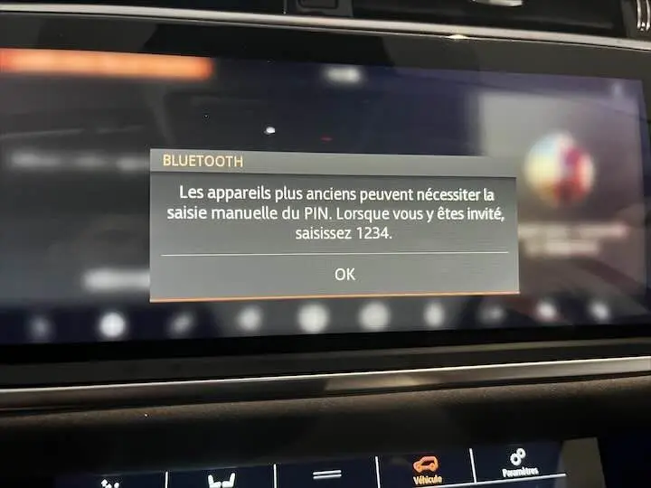 Écran tactile intérieur du Range Rover Evoque noir Santorini affichant un message Bluetooth pour saisie manuelle du PIN.