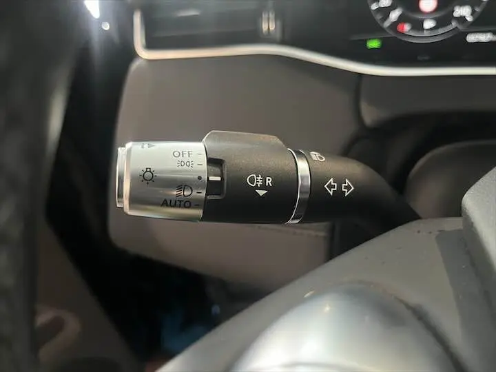Gros plan sur la commande des feux et clignotants du Range Rover Evoque noir Santorini, côté gauche du volant.