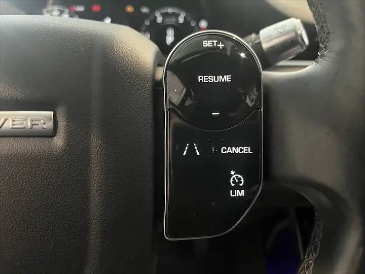 Gros plan sur les commandes de régulateur de vitesse à droite du volant noir du Range Rover Evoque 2020.