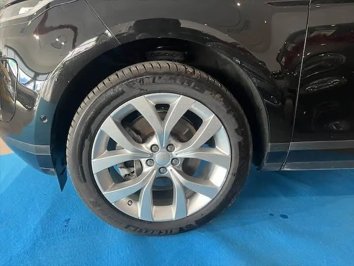 Gros plan sur la roue avant gauche en alliage du Range Rover Evoque noir Santorini, avec pneu Michelin visible.