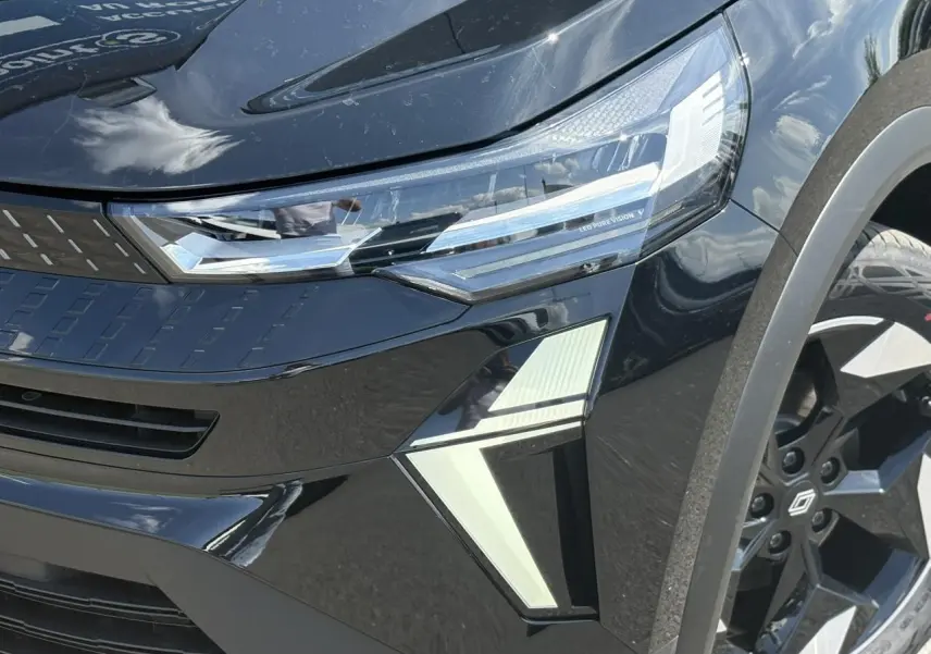 Gros plan sur l'avant droit du Renault Captur noir étoile 2025, mettant en valeur les phares LED Pure Vision et la jante aluminium.