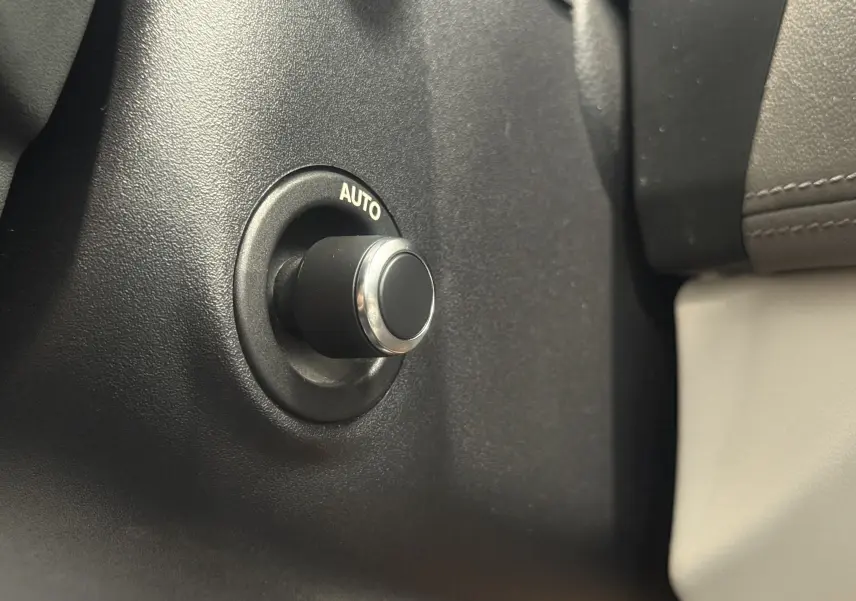 Bouton rotatif "AUTO" en gros plan sur le tableau de bord intérieur beige du Jaguar XE 20d 2015.