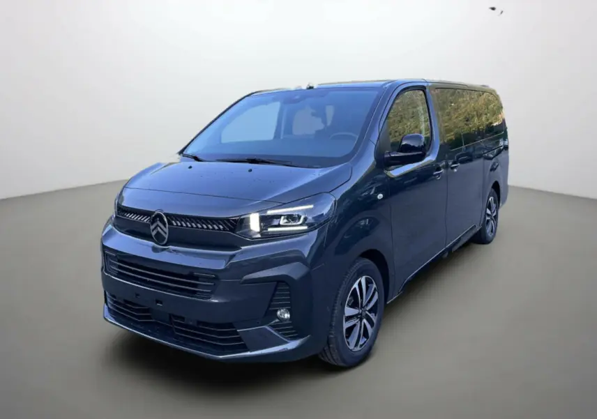 Citroën Spacetourer 180 EAT8 Business Pack gris acier en vue 3/4 avant, avec calandre et phares modernes allumés.