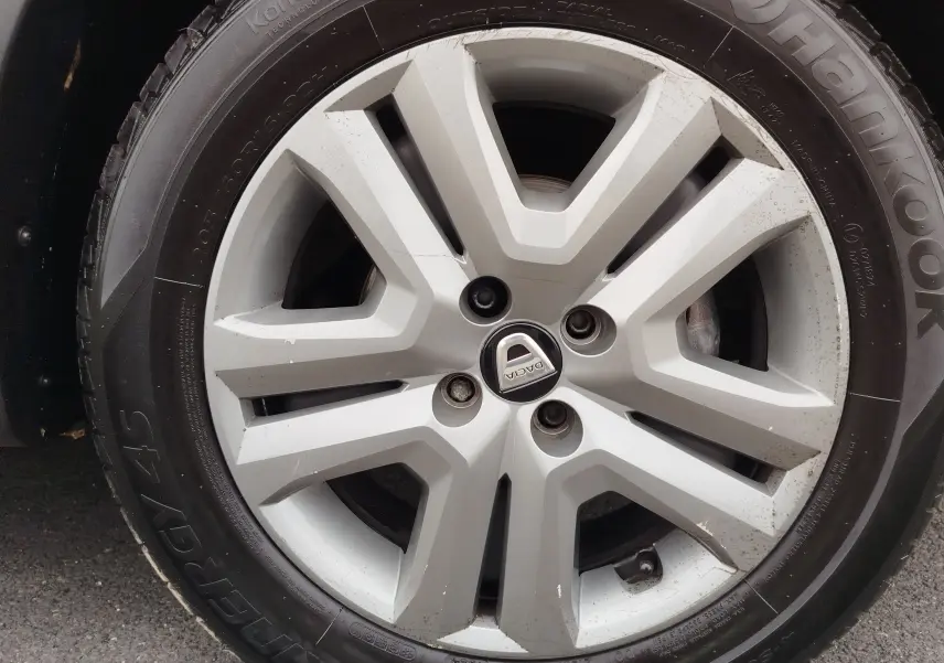 Gros plan sur la jante alliage argentée avec logo Dacia d'une Sandero Stepway blanc glacier de 2021.