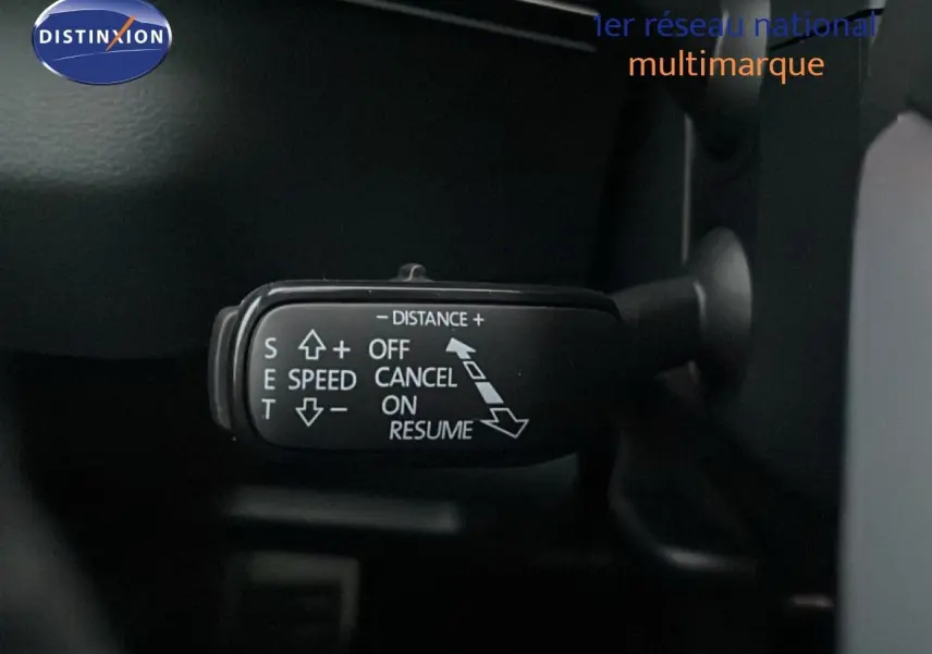 Gros plan sur la commande de régulateur de vitesse du Skoda Karoq gris argent 2025, intérieur noir visible.