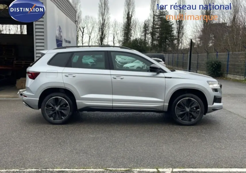 Profil droit d’un Skoda Karoq gris argent métallisé 2025, version Sportline avec jantes noires et détails sportifs.