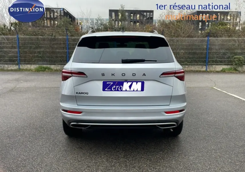 Vue arrière d'un Skoda Karoq gris argent métal 2025, avec feux LED et double sortie d'échappement intégrée.