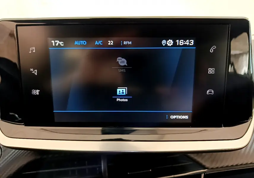 Écran tactile central du tableau de bord de la Peugeot 2008 gris foncé, affichant les options multimédia et climatisation.