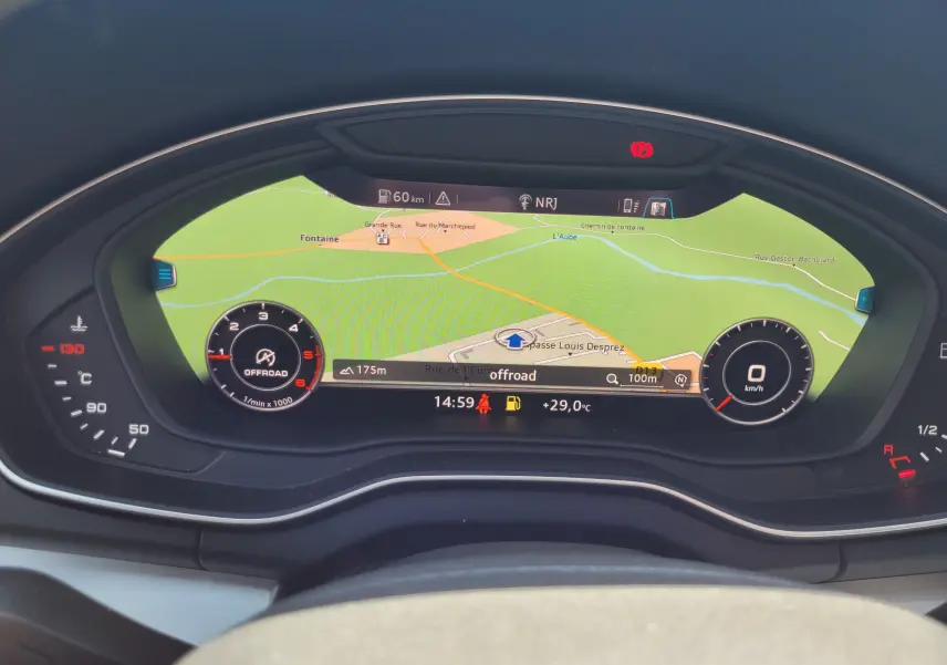 Vue rapprochée du tableau de bord numérique de l'Audi Q5 2018, affichant la navigation et les compteurs en mode offroad.