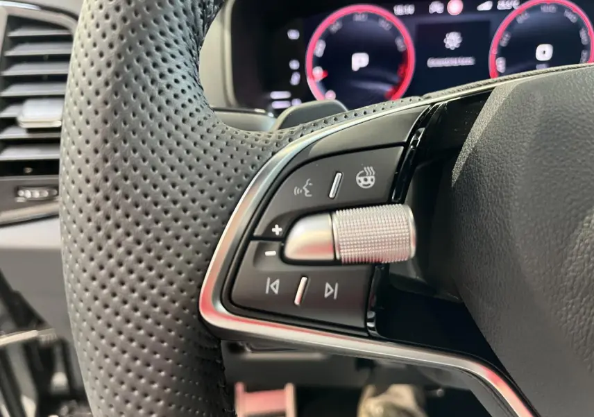 Gros plan sur la commande multifonction gauche du volant perforé noir du Skoda Karoq 2025 finition Sportline.