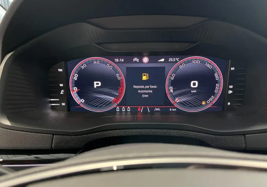 Tableau de bord digital du Skoda Karoq 1.5 TSI Sportline affichant vitesse et message de carburant faible.