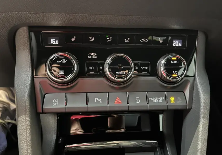 Panneau de climatisation automatique tri-zone noir brillant avec commandes rotatives et boutons multifonctions dans un Skoda Karoq gris Sportline 2025