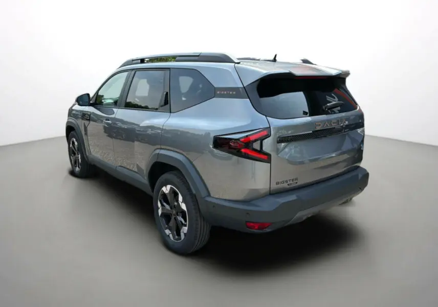 Vue 3/4 arrière droite du Dacia Bigster 2025 gris schiste, avec logo et feux arrière en forme de flèche rouge.