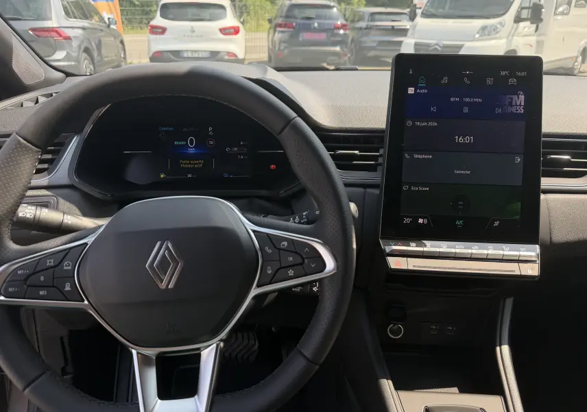 Vue intérieure avant du tableau de bord et volant Renault Captur 2026, avec écran tactile vertical et commandes au volant.
