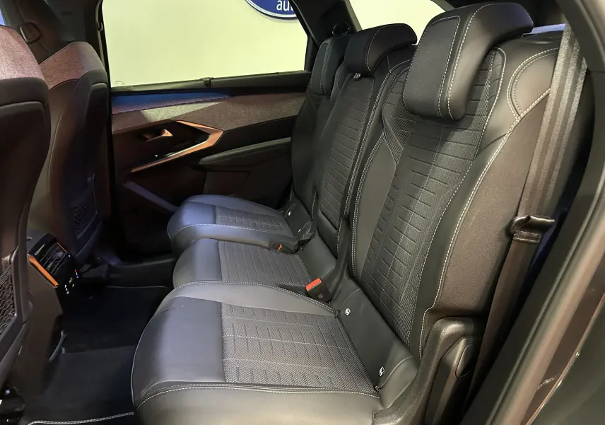 Vue intérieure côté droit des sièges arrière en cuir noir avec surpiqûres blanches du Peugeot 5008 III Hybrid 145 GT gris titane.