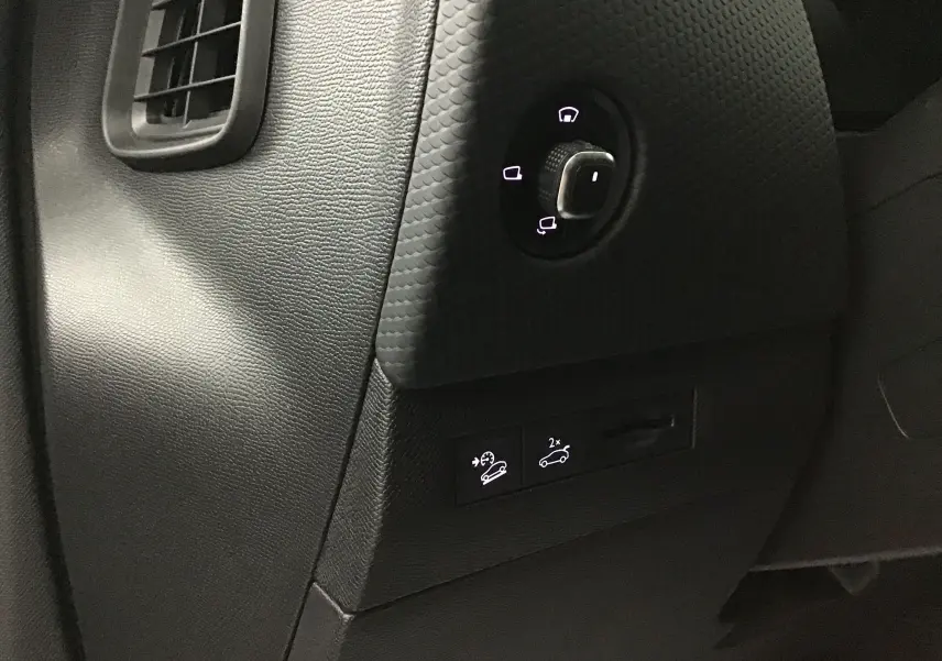 Détail du tableau de bord côté gauche du DS4 noir 2022, avec commandes éclairées pour rétroviseurs et aides à la conduite.