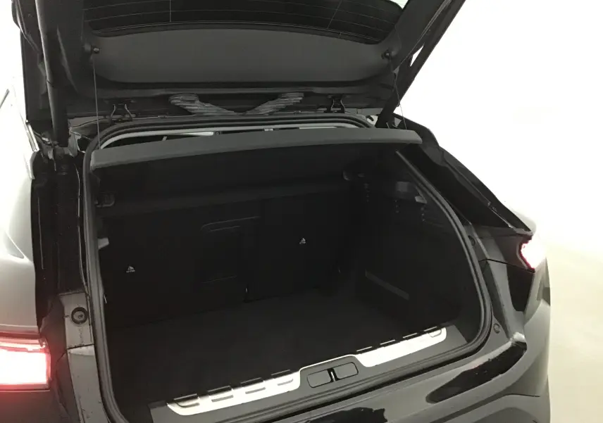 Coffre ouvert en vue arrière d'une DS4 noire 2022, mettant en valeur l'espace de chargement et les feux arrière allumés.