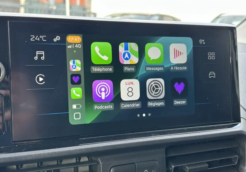 Écran tactile 10 pouces du Peugeot Partner Fourgon 2025 affichant Apple CarPlay avec plusieurs applications visibles.