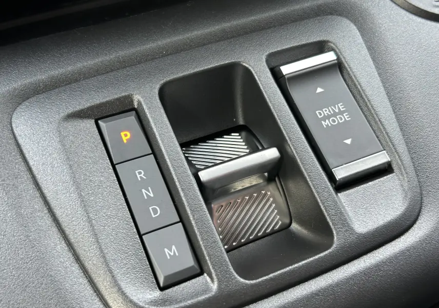 Gros plan sur la commande de boîte automatique et le sélecteur de mode de conduite du Peugeot Partner Fourgon blanc.
