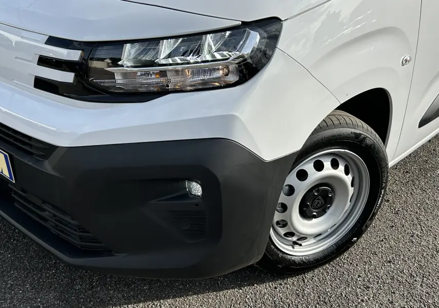 Gros plan sur l'avant droit blanc du Peugeot Partner Fourgon avec phare moderne et pare-chocs noir mat.