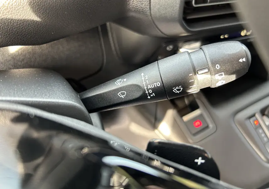 Gros plan sur la commande d'essuie-glace et la palette de changement de vitesse dans l'habitacle du Peugeot Partner Fourgon blanc.