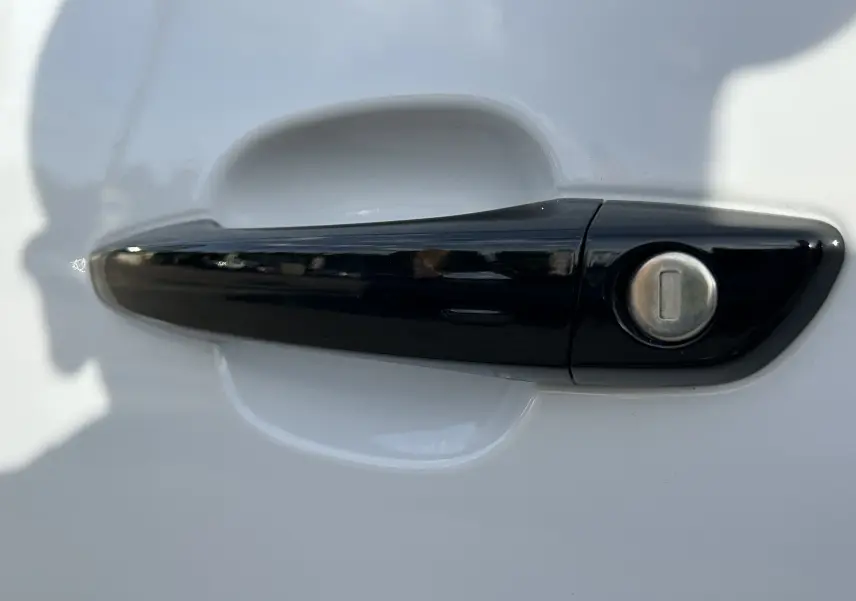Poignée de porte noire en gros plan sur la portière blanche d'un Peugeot Partner Fourgon 2025.