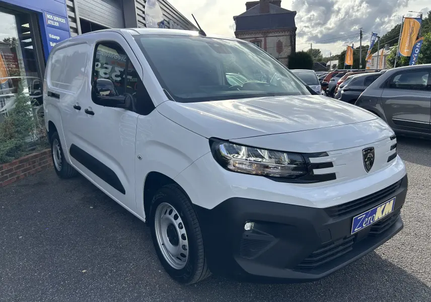 Fourgon Peugeot Partner blanc vu en 3/4 avant droit, avec pare-chocs noir et jantes acier simples.