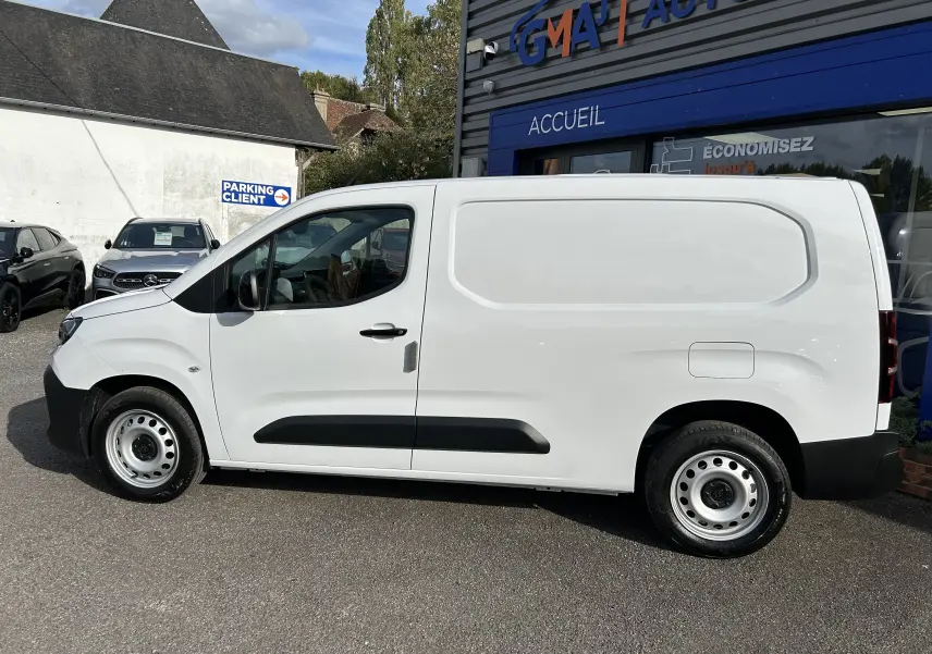 Peugeot Partner Fourgon blanc vu de profil côté gauche, avec plancher bois et protections noires sur les portières.