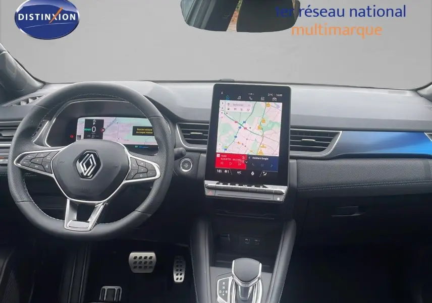 Intérieur moderne du Renault Captur E-Tech hybride 2025, vue du poste de conduite avec écran tactile central et volant multifonction.