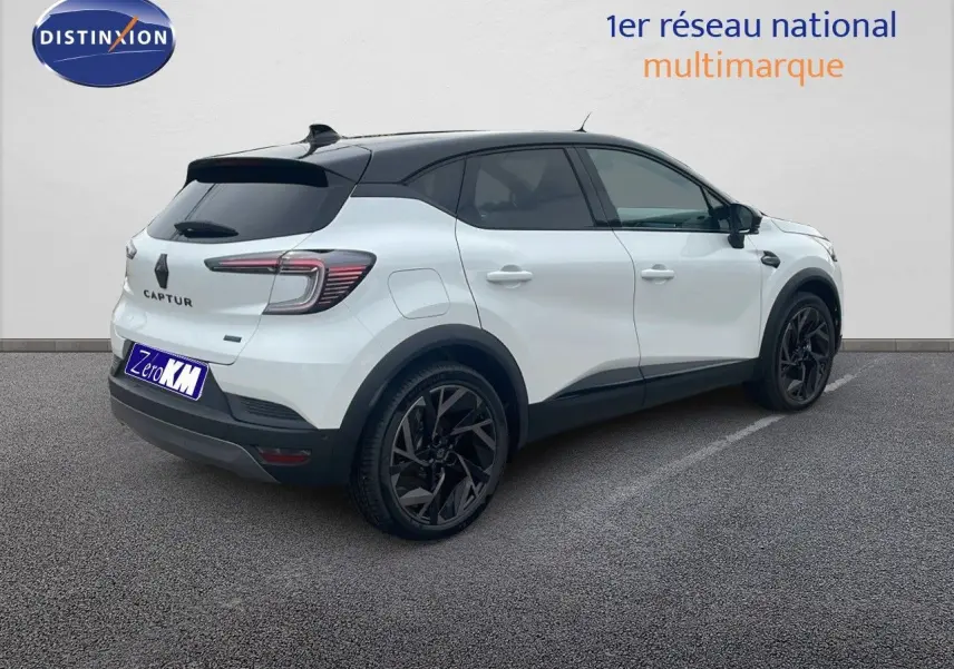Renault Captur E-Tech hybride blanc nacré avec toit noir, vue 3/4 arrière côté gauche, jantes noires distinctives.