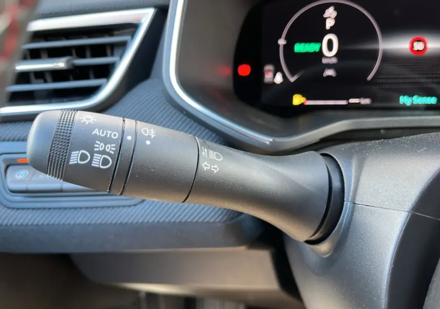 Gros plan sur la commande des feux et clignotants à gauche du tableau de bord de la Renault Clio V E-Tech 145 Esprit Alpine Bose.