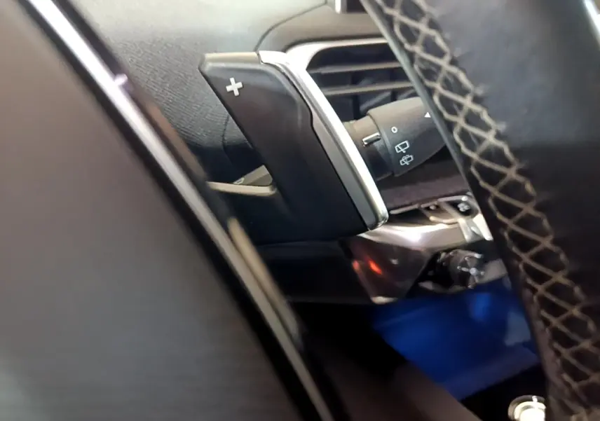 Gros plan sur la palette de changement de vitesse côté droit du volant cuir du Peugeot 3008 blanc hybride rechargeable.