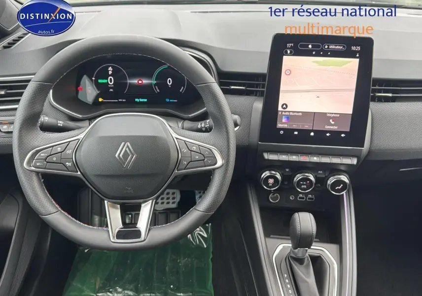 Vue intérieure avant de la Renault Clio V 1.6 e-tech avec volant multifonction et écran tactile central lumineux