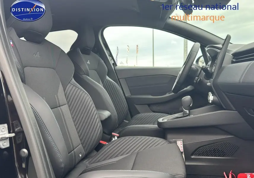 Intérieur côté gauche de la Renault Clio V hybride noir étoile, sièges sport esprit Alpine avec surpiqûres bleues.