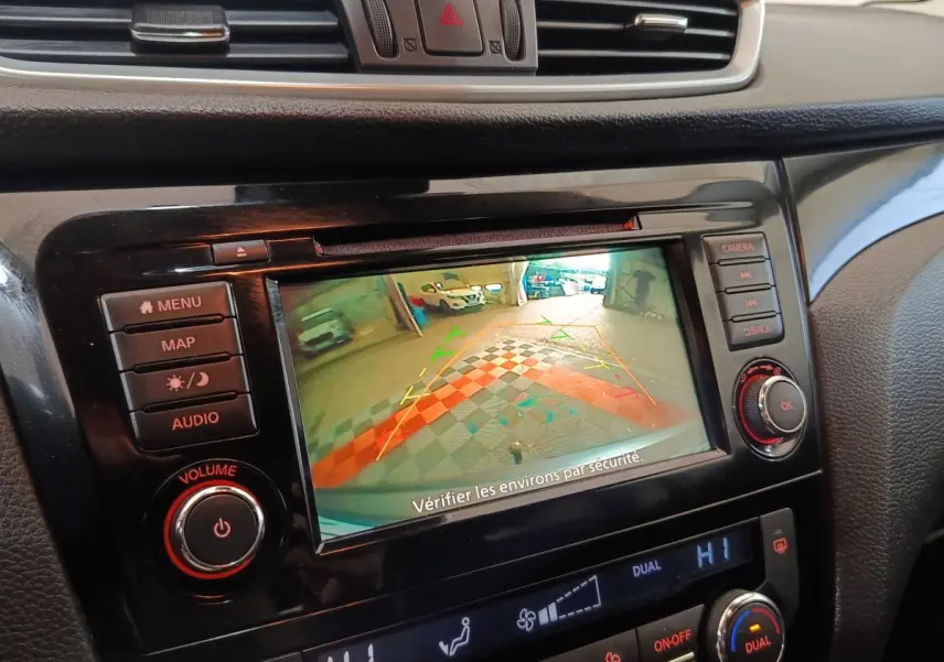Écran tactile central du Nissan Qashqai 2019 gris clair montrant l'aide au stationnement arrière en intérieur.