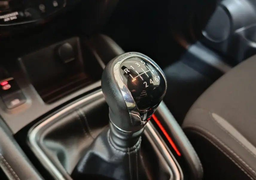 Le levier de vitesses manuel noir du Nissan Qashqai 1.5 DCI 115 Business Edition vu en gros plan intérieur.