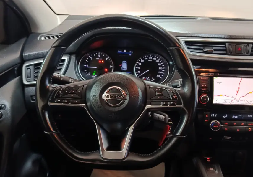 Vue rapprochée du volant en cuir noir et du tableau de bord avec écran tactile de navigation du Nissan Qashqai gris clair 2019.