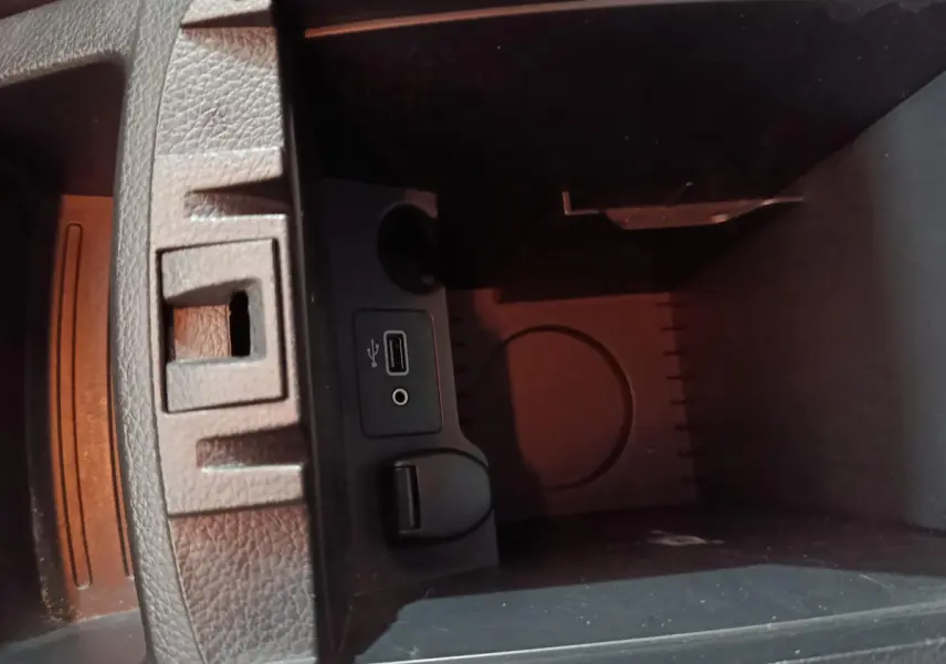 Vue rapprochée de la console centrale du Nissan Qashqai gris clair, montrant prise USB et prise jack audio.