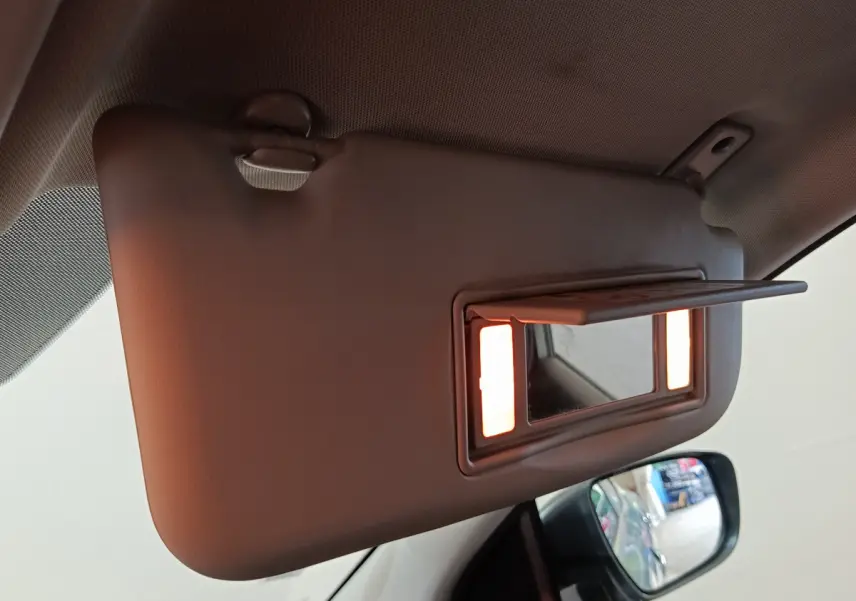 Miroir de courtoisie éclairé sur pare-soleil côté conducteur dans l'habitacle d'un Nissan Qashqai gris clair 2019.