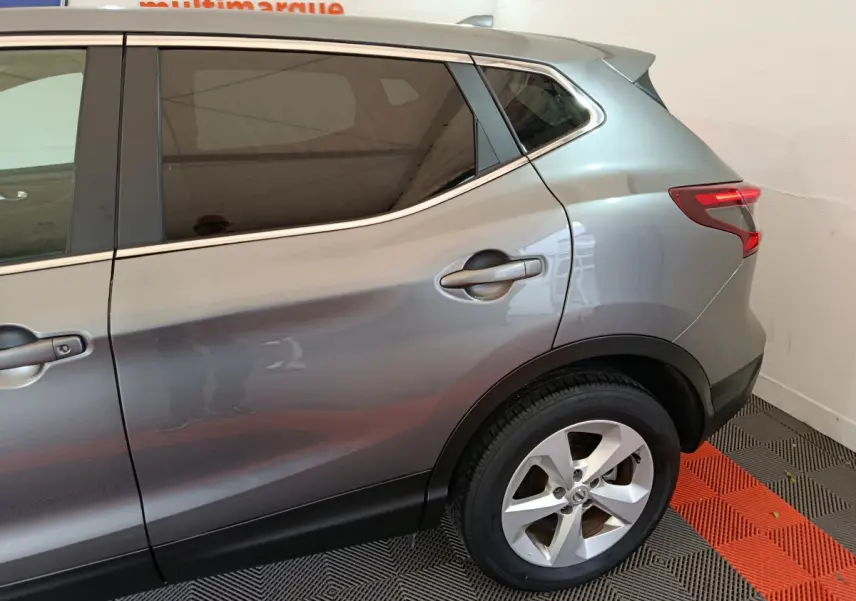 Vue latérale côté droit du Nissan Qashqai gris clair 2019, mettant en valeur la porte arrière et la roue arrière.